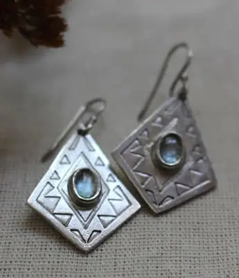 Aretes que muestran un diamante mexicano, un tipo de greca geométrica típica