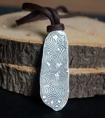 Collar La piedra guardiana de Newgrange que retoma el motivo de la piedra neolítica.