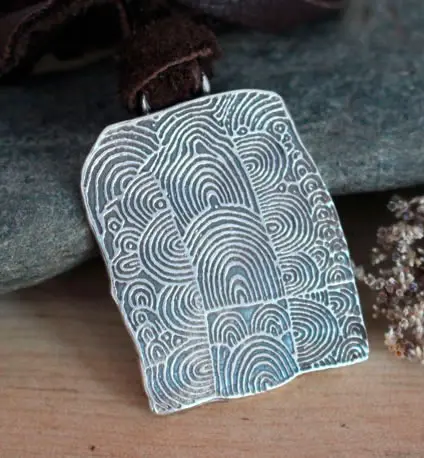 Collar Túmulo de Gavrinis que muestra los motivos neolíticos de una de las piedras del pasillo del dolmen.