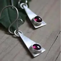 Aretes triangulares de plata y piedra de nacimiento.
