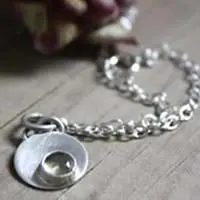 Pulsera circular de plata y piedra de nacimiento.