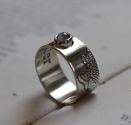 Anillo grabado con una carpa japonesa y una piedra lunar.