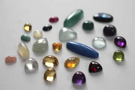 Una selección de cabujones en diferentes formas para crear una pieza de joyería que refleje su personalidad, incorporando sus piedras de nacimiento.