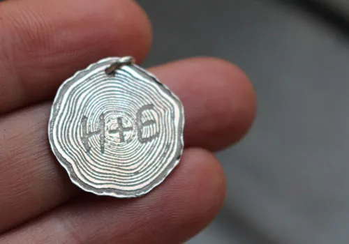 Árbol grabado, dije iniciales en el tronco de un árbol en plata