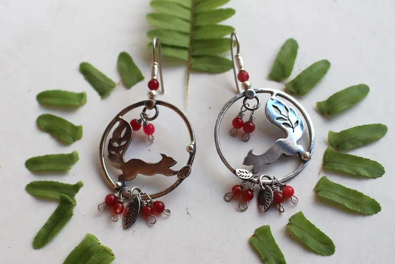 Bajo las bayas, aretes ardilla y bayas rojas en plata y coral