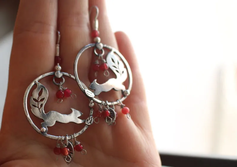 Bajo las bayas, aretes ardilla y bayas rojas en plata y coral