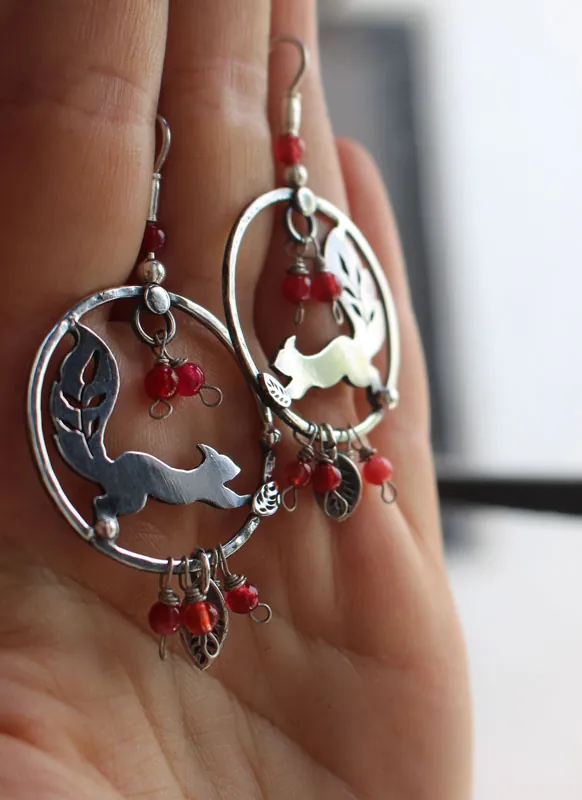 Bajo las bayas, aretes ardilla y bayas rojas en plata y coral