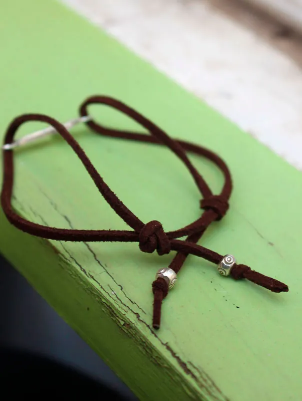 Decisión, pulsera con cruz grabada en plata y cordón de gamuza