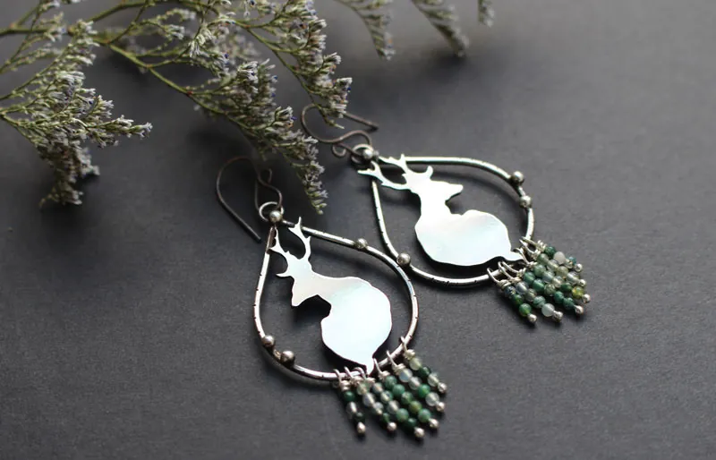 En la tranquilidad del amanecer, aretes ciervos en plata y ágata musgosa