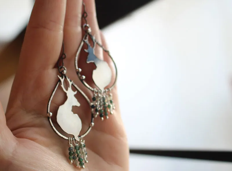 En la tranquilidad del amanecer, aretes ciervos en plata y ágata musgosa