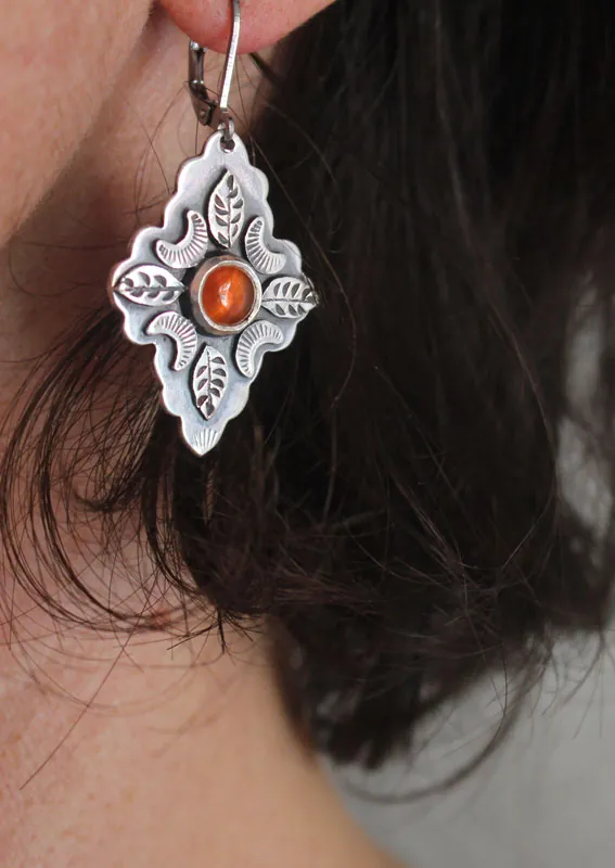 Farándula bajo la luna naranja, aretes de hojas y lunas en plata y cornalina