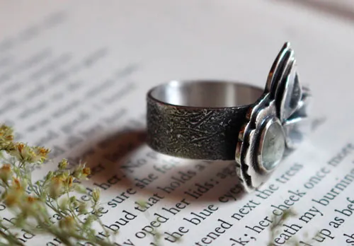 Florecer bajo el universo, anillo flor y pétalos en plata y zafiro transparente