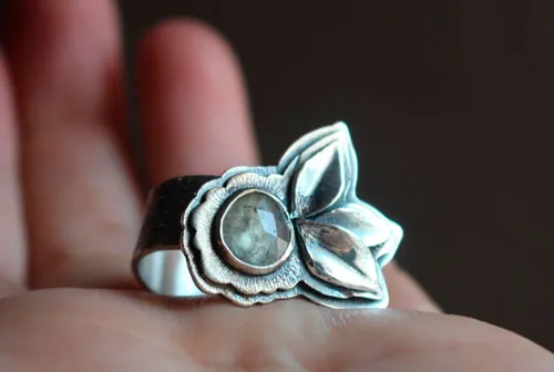 Florecer bajo el universo, anillo flor y pétalos en plata y zafiro transparente
