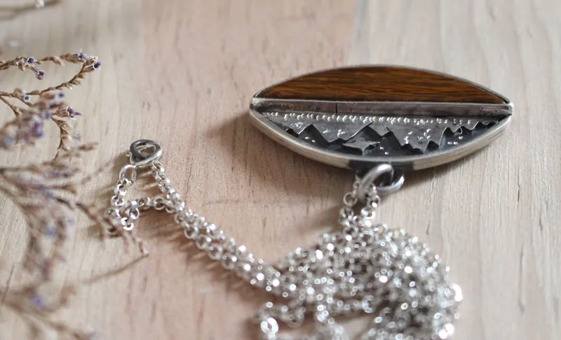 Hacia los cielos, collar águila de la montaña en plata y madera petrificada