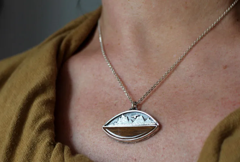Hacia los cielos, collar águila de la montaña en plata y madera petrificada