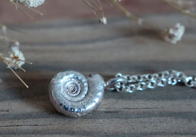 La cuna de la vida, collar náutilo Ammonita con piedra de nacimiento en plata y rubí