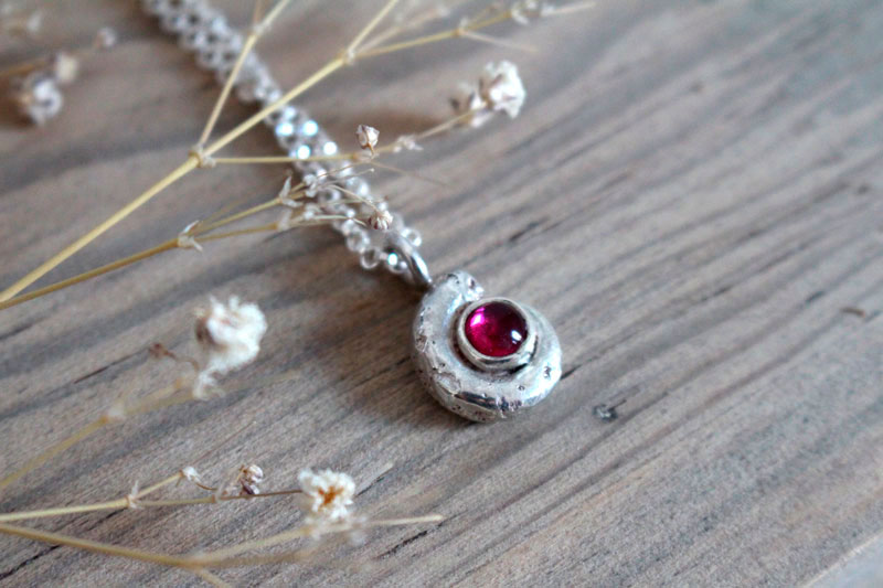 La cuna de la vida, collar náutilo Ammonita con piedra de nacimiento en plata y rubí