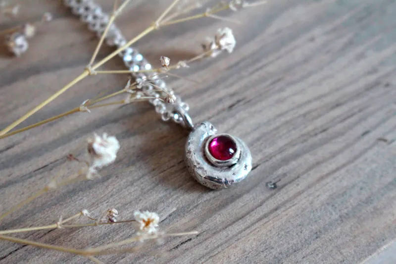 La cuna de la vida, collar náutilo Ammonita con piedra de nacimiento en plata y rubí