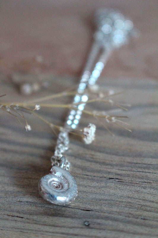 La cuna de la vida, collar náutilo Ammonita con piedra de nacimiento en plata y rubí