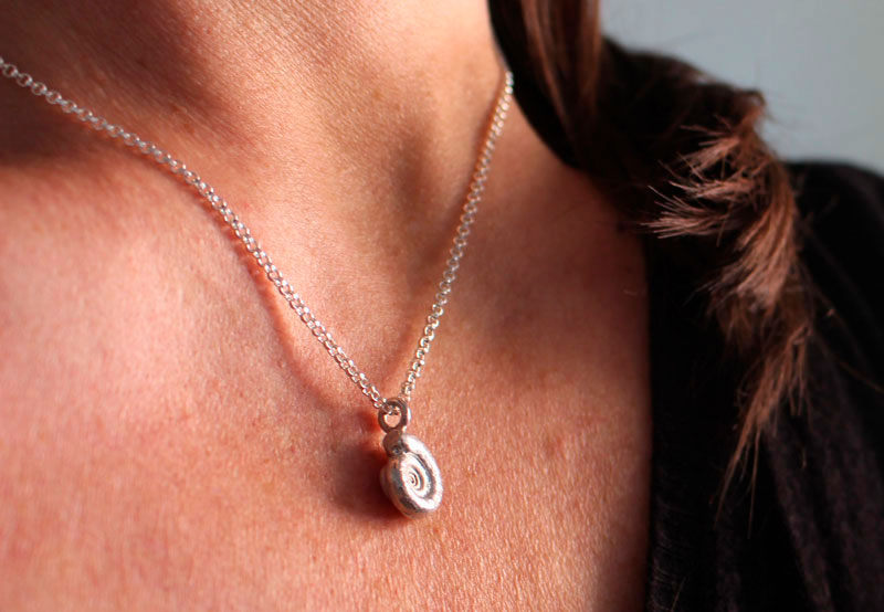 La cuna de la vida, collar náutilo Ammonita con piedra de nacimiento en plata y rubí