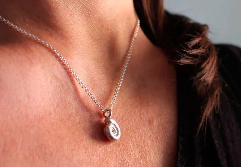 La cuna de la vida, collar náutilo Ammonita con piedra de nacimiento en plata y rubí