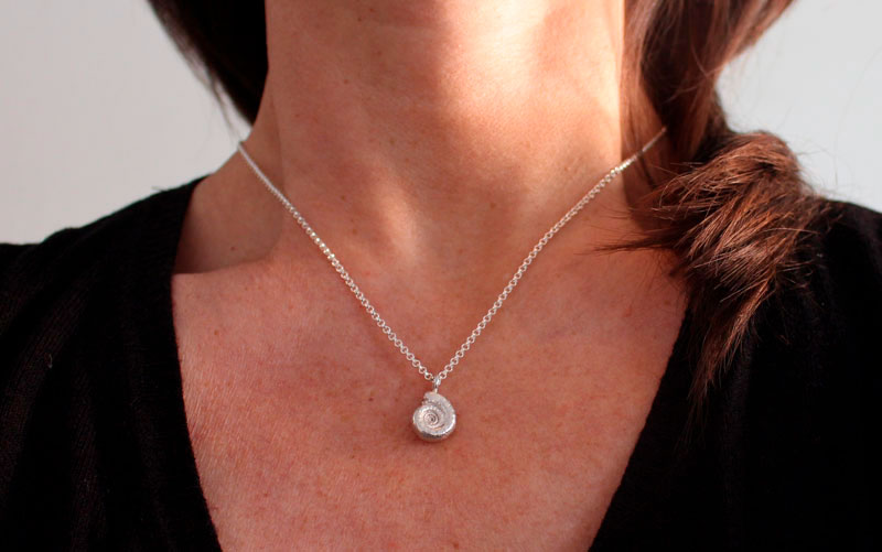 La cuna de la vida, collar náutilo Ammonita con piedra de nacimiento en plata y rubí