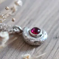 La cuna de la vida, collar náutilo Ammonita con piedra de nacimiento en plata y rubí