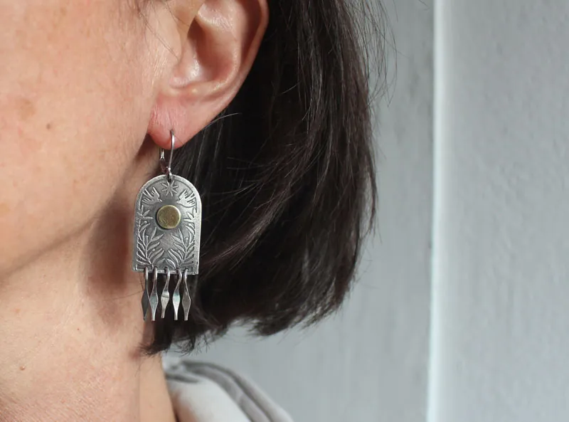 La puerta de las estrellas, aretes de plata y latón