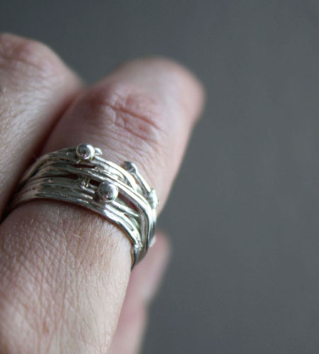 Las raíces del azar, anillo de tejido del hilo de la vida griego en plata