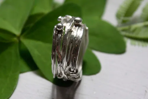 Las raíces del azar, anillo de tejido del hilo de la vida griego en plata