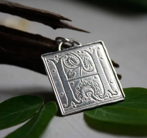 Letra capitular, dije inicial con iluminación medieval en plata