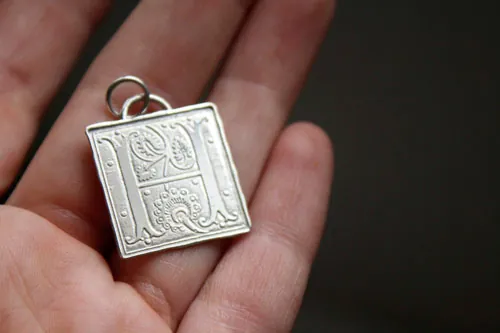 Letra capitular, dije inicial con iluminación medieval en plata
