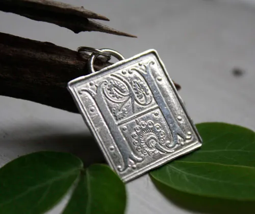 Letra capitular, dije inicial con iluminación medieval en plata