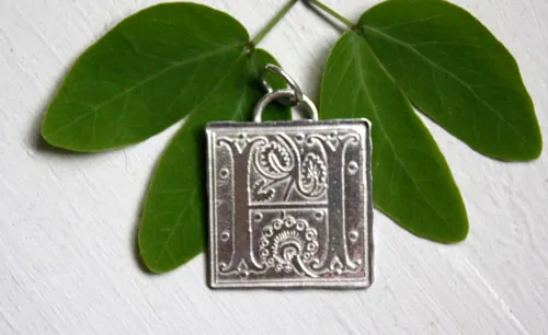 Letra capitular, dije inicial con iluminación medieval en plata