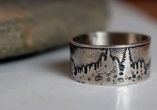Más allá de las cumbres, anillo montaña y bosque en plata