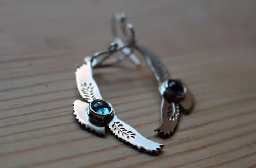 Mensajes del amanecer, aretes águila en plata y zircón azul