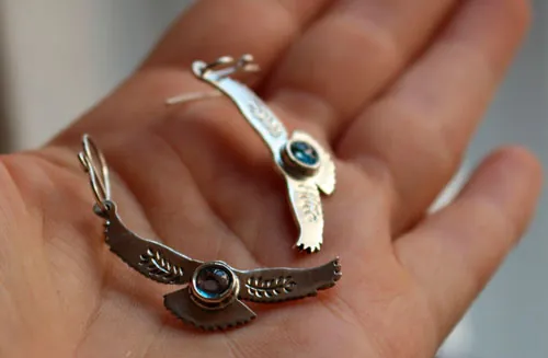 Mensajes del amanecer, aretes águila en plata y zircón azul