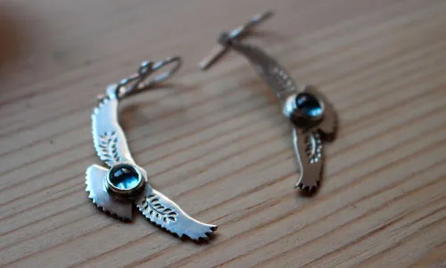 Mensajes del amanecer, aretes águila en plata y zircón azul