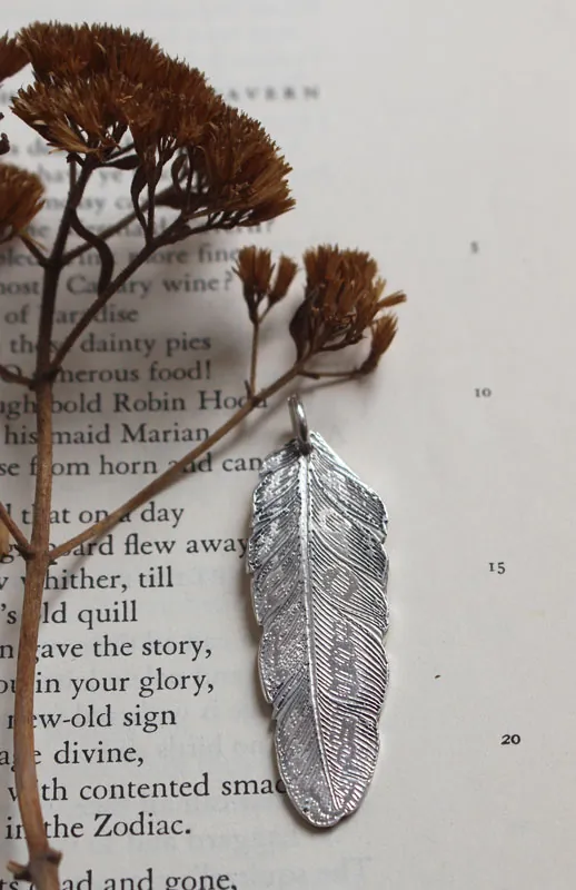 Pluma, dije paz y libertad en plata