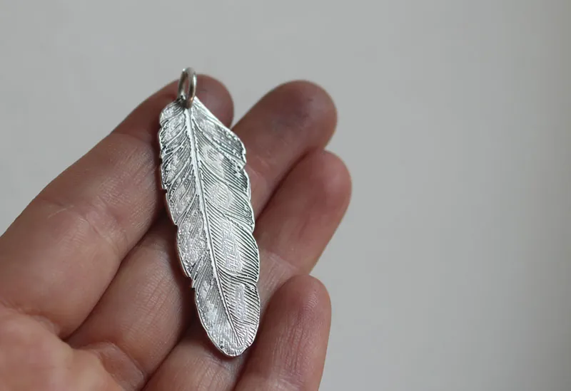 Pluma, dije paz y libertad en plata