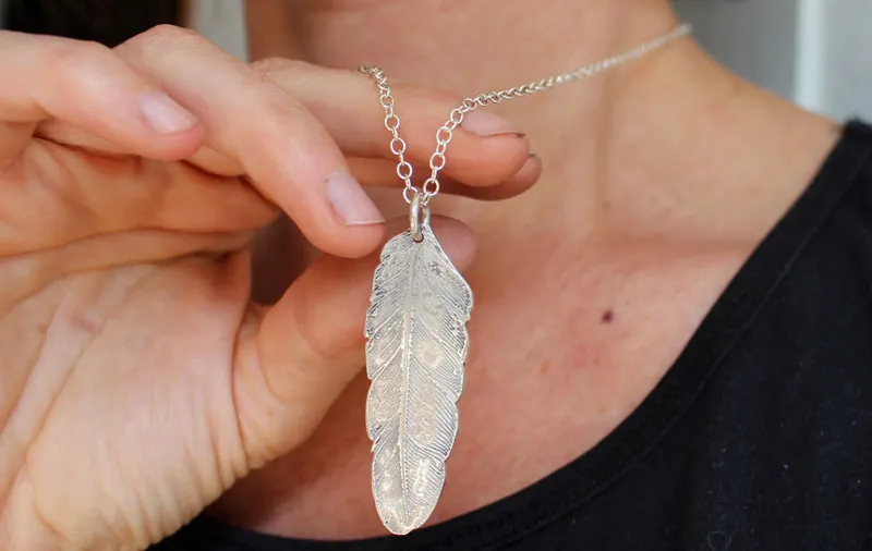 Pluma, dije paz y libertad en plata